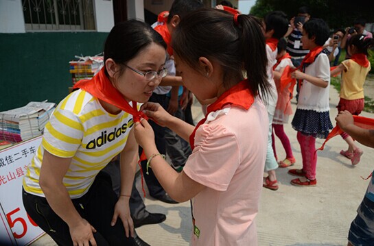 捐贈儀式上，孩子們?yōu)閻坌奶焓瓜瞪霞t領(lǐng)巾