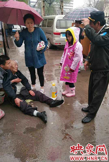 女孩為倒地老人撐傘。