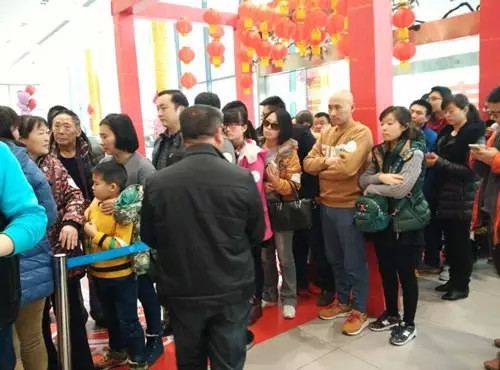 排隊(duì)領(lǐng)年貨，一家老小齊上陣。