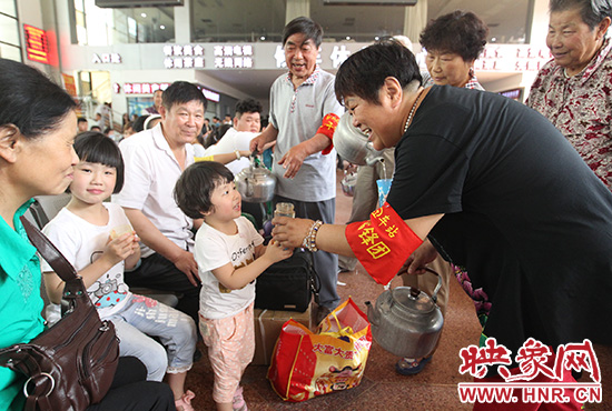 老年雷鋒團(tuán)”志愿者在候車廳為旅客送水。