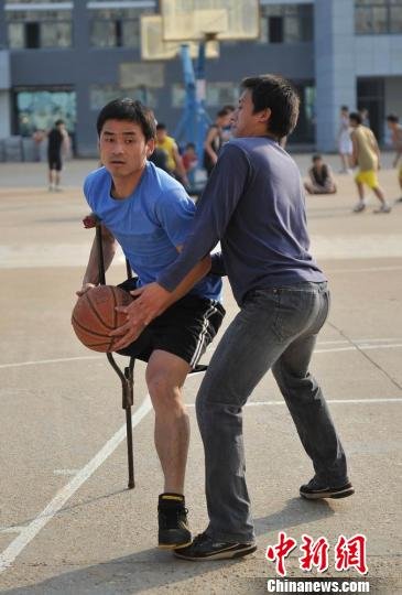 圖為拄著拐杖的瞿詩濤和同學(xué)搶球。劉占昆攝