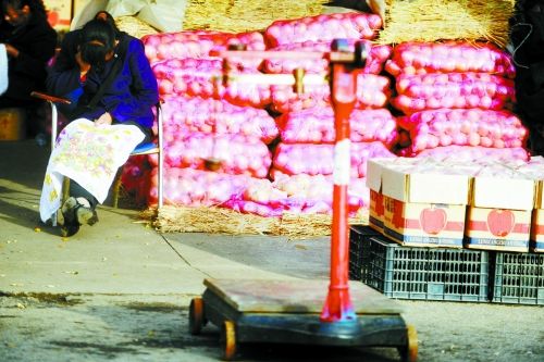 水果批發(fā)市場內(nèi)，沒有客戶時，商戶在繡十字繡