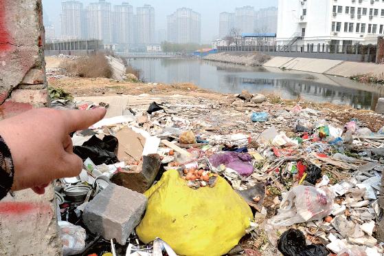 金水河長江路橋下河水發(fā)臭，水邊堆放眾多垃圾