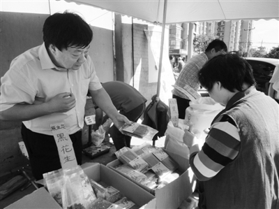 昨日，河南企業(yè)家劉春喜在京“練攤”，為顧客挑選綠豆。新京報記者 張玉學 攝