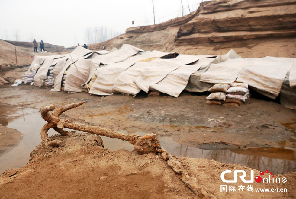 2014年1月6日，河南洛陽古沉船發(fā)掘現(xiàn)場，古沉船鐵錨從見天日，靜靜地躺在古船旁。