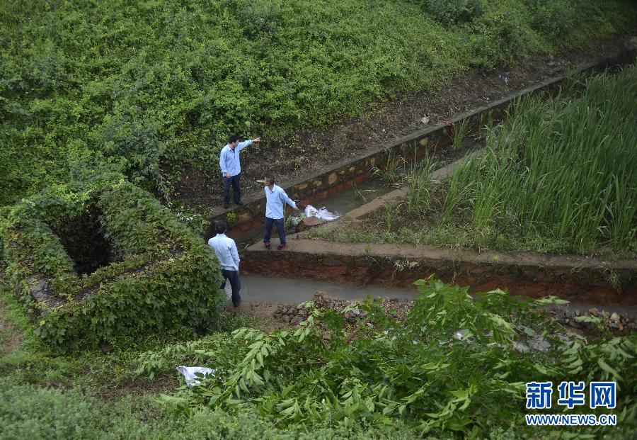 5月18日，工作人員在槽罐車泄漏現(xiàn)場附近的水渠邊查看情況。