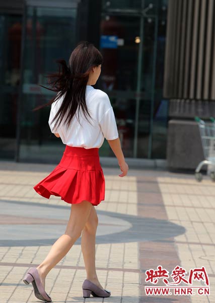 短裙美女在陽(yáng)光下匆匆而過