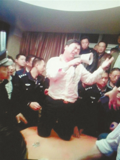 　4月19日，泰州市濱江工業(yè)園區(qū)管委會(huì)招待中心，一男子跪在酒桌上喊話求饒。李根 攝