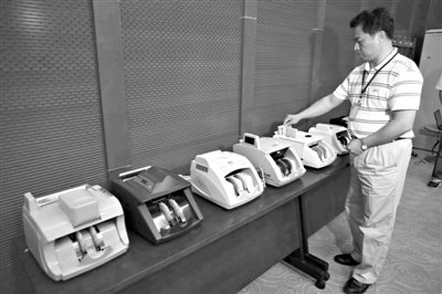 昨日，央行工作人員用各種驗(yàn)鈔機(jī)對C1F9假幣進(jìn)行測試，機(jī)器均能及時作出異常報警反應(yīng)。新京報記者 浦