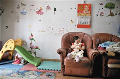 6月14日，未婚媽媽于軍的家里。女兒悅悅抱著兔子玩偶，在聽媽媽手機上的兒歌，這個4歲女孩喜歡兔子。