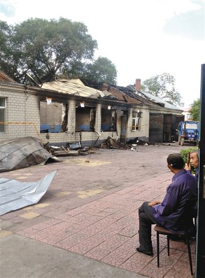 7月27日，海倫聯(lián)合敬老院內(nèi)，幾名老人看著對(duì)面被燒毀的特護(hù)病房。新京報(bào)記者 涂重航 攝