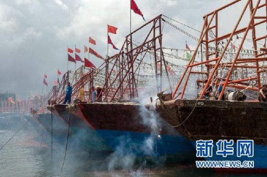 2013年8月1日 南海開漁日 臨高迎新港 8月1日，海南省臨高縣漁民在船上鳴放鞭炮慶祝武蓮港開港。