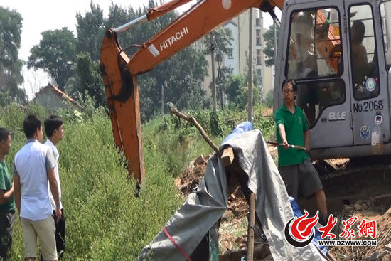 陳寶成手持自制刀斧守在挖掘機旁阻止便衣民警靠前。駕駛室內(nèi)，張朋珂正向受害人郭曉剛身上澆汽油。（視頻截圖）