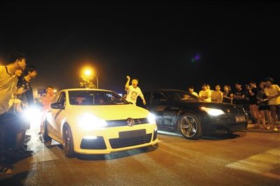8月24日晚，東壩中街飆車現(xiàn)場(chǎng)，兩輛車并排等待出發(fā)指令，旁邊許多愛好者前來(lái)觀看比賽。新京報(bào)記者
