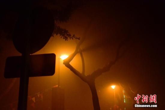 1月31日凌晨，市民行走在煙霧繚繞的南京街頭。當(dāng)天是農(nóng)歷馬年正月初一，南京有限開禁燃放煙花爆竹正逢下霧天，空氣的不流通致使煙花爆竹燃燒后產(chǎn)生的顆粒物不能及時散開，造成整座城市煙霧繚繞。據(jù)當(dāng)?shù)丨h(huán)保部門發(fā)布的信息顯示，空氣質(zhì)量屬重度污染。中新社發(fā) 泱波 攝