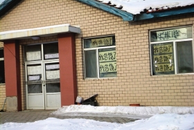 伊春市帶嶺區(qū)一排破舊的平房，房間窗戶上貼滿了“我告饒了”的字樣。
