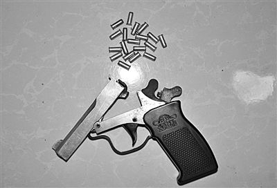 警方從搶劫嫌疑人處起獲的贓款和發(fā)令槍、子彈。警方供圖