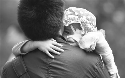 昨日，北京同仁醫(yī)院，被砍傷的彤彤趴在舅舅的肩上。他們剛剛掛完號，正準(zhǔn)備回旅館。新京報(bào)記者 尹亞飛 攝