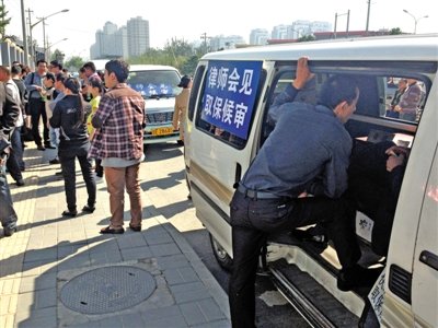 昨日，朝陽區(qū)看守所門前有人排隊。大門外還停有多輛寫有“律師會見”字樣的車。