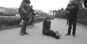 鄭大姐坐在地上，警方趕到進行施救。（視頻截圖由警方提供）