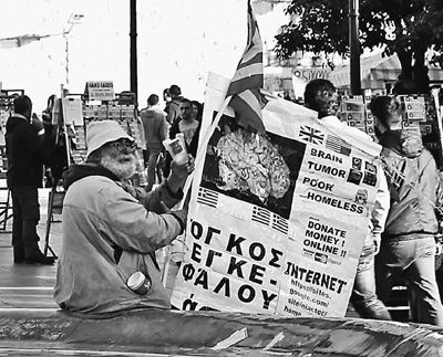 自債務危機爆發(fā)以來，希臘承諾實施以減薪、增稅、裁員和私有化為主要內(nèi)容的緊縮和改革政策。一系列的緊縮措施使民眾生活受到嚴重影響，約1/4的家庭陷入貧困。圖為今年1月希臘大選期間，在雅典市中心國會大廈前廣場乞討的老人。