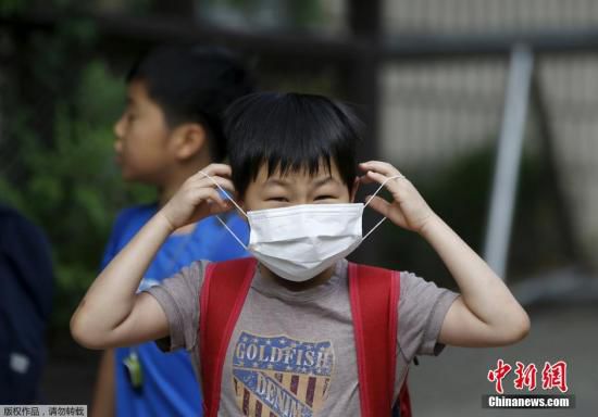 圖為當(dāng)?shù)貢r間2015年6月8日，韓國未停課的學(xué)校，學(xué)生課前戴口罩測體溫。