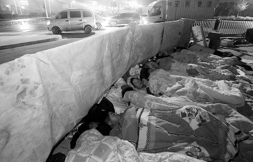 在寒冷的冬夜，為了能省點錢，方便接活，民工們仍睡在橋下。