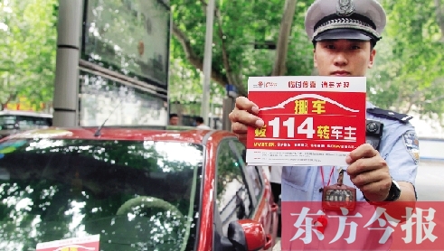 8月27日，鄭州市緯一路與經(jīng)七路交叉口，交警將“挪車請(qǐng)撥打114轉(zhuǎn)車主”的提示牌放在路邊?？康能嚿? width=
