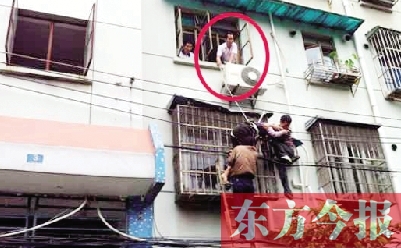 施救現(xiàn)場，劉鵬（圈內(nèi)）先用繩子捆住老太確保安全 勞動報記者 郭娜 供圖