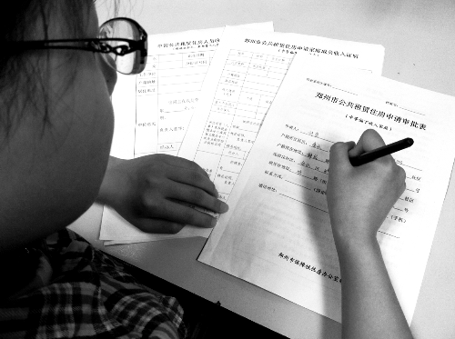 一位女士在填寫公租房申請審批表 一位女士在填寫公租房申請審批表