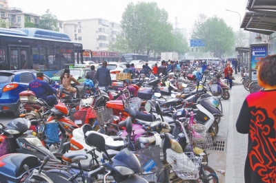 省人民醫(yī)院北門，路邊的公交站牌處停滿非機(jī)動車，上、下客只能在快車道上。