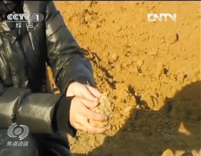 麻剛沙系麻剛石粉碎而成。記者找到一塊麻剛石，一捏就碎成粉末，硬度非常差。央視截圖