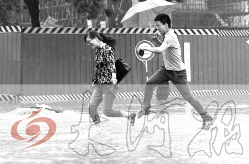 鄭州經(jīng)三路與北環(huán)交叉口處，積水較深，行人們不得不“練輕功”。 記者 白周峰 攝影