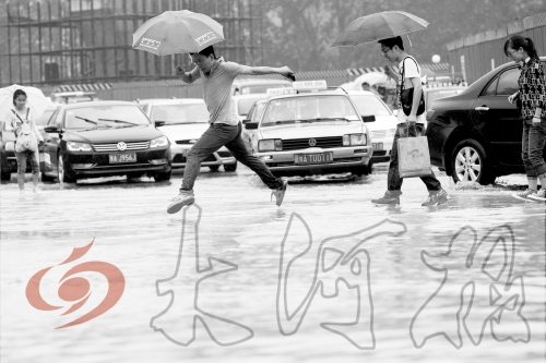 鄭州經(jīng)三路與北環(huán)交叉口處，積水較深，行人們不得不“練輕功”。 記者 白周峰 攝影