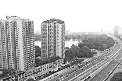 昨日，人濟山莊小區(qū)，與其他樓相比，B棟樓頂層天臺上違規(guī)建造了一棟兩層小樓，假山大樹俱全。新京報記者