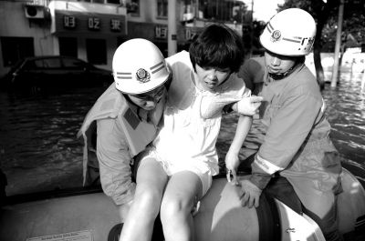 10月10日，前來余姚支援的杭州消防支隊武警官兵在南西路幫助轉(zhuǎn)移被困群眾。新華社發(fā)