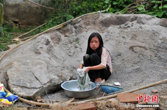 8月9日，云南巧家紅石巖村，10歲的劉鑫蕊在洗自己的衣服