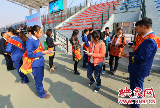 活動(dòng)現(xiàn)場工作人員給同學(xué)們發(fā)放宣傳冊(cè)、環(huán)保袋。