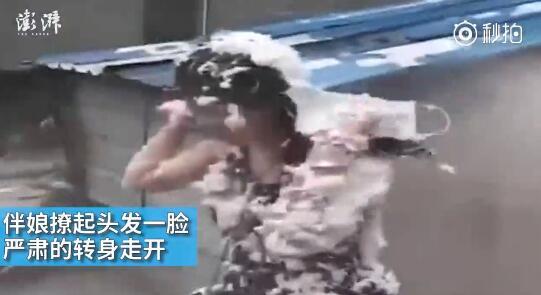 視頻中可以看到，雖然伴娘事先有穿雨衣防備，但在被伴郎團圍攻時，雨衣被拔下，更過分的是，有人還用滅火器直接對著她的臉噴。后來伴娘好像是生氣了，撩起頭發(fā)一臉嚴肅的轉身走開。