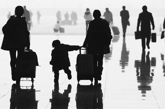 昨日，鄭州東站，一名孩子拉著媽媽和包裹快樂(lè)地奔走在春運(yùn)的途中