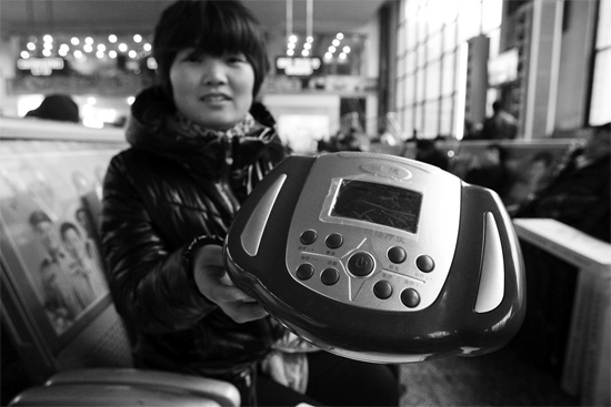 火車站候車室，李女士向記者展示她準(zhǔn)備孝敬父母的按摩儀