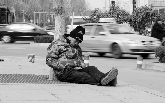 2月2日，鄭州市中州大道農(nóng)業(yè)路立交橋下，50歲的王文德打算在臨近春節(jié)前再接些零活兒，由于疲憊，他睡著