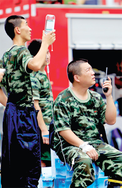 火場外，被消防戰(zhàn)士稱為“李大隊”的救援人員掛著吊瓶現(xiàn)場指揮