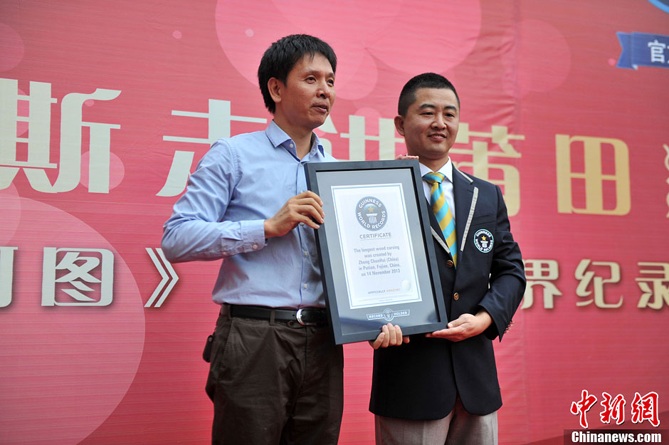 圖為世界吉尼斯認證官為鄭春輝（左）頒發(fā)證書。呂明 攝