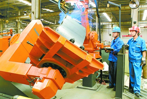 圖為龍工集團(tuán)中原公司的職工正在操作機(jī)器人焊接裝載機(jī)。