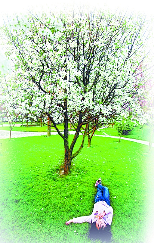 　孩子愜意地躺在社區(qū)內(nèi)的草坪上。