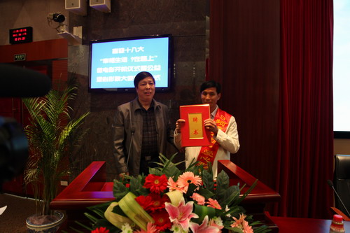 河南平頂山魯山縣電視臺的記者張朝岑，接過了河南電視臺9頻道總監(jiān)張克宣遞上的聘書。