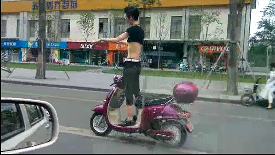 奇葩男子電動(dòng)車(chē)上秀雜技 戴墨鏡大撒把