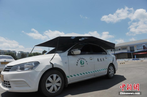 杭州一駕校現(xiàn)遮陽(yáng)新招 教練車車頂撐傘
