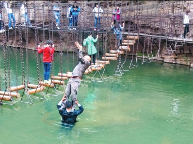 中年男游客正踩著景區(qū)安全員郭小明的肩膀過河。網(wǎng)友“@我的小名叫張孩”供圖